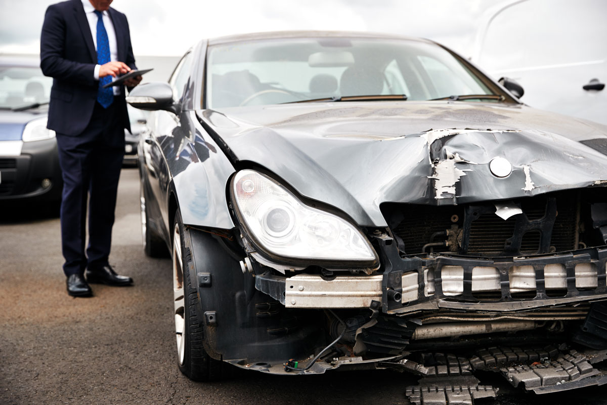 insurance adjuster reviewing damage to a car